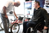 Joel Bach, Colorado School of Mines professor, shows Army veteran Tyler Wilson an adaptive mountain bike in the lab.