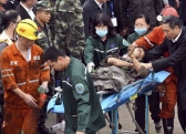 In this photo released by China's Xinhua News Agency, a worker is carried on a stretcher out of the Longyun coal mine.