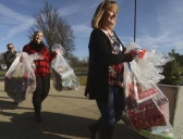 Katie Sweppy and Criss Eyer employees at Peabody Coal’s Bear Run Mine in Carlisle, carry in bags of presents for students.