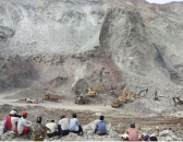 Local jade scavengers watch authorities use backhoes to uncover bodies at the site of a landslide Friday May 4.