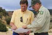 New Mexico Land Commissioner Aubrey Dunn,and Larry Gore with the U.S. Forest Service look at survey maps of the Nacimiento Mine.