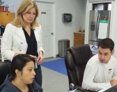 Mined Minds co-founder Amanda Laucher helps two students working on an app for a local business.