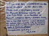 A hand written sign is posted on a damaged kiosk at the Avondale Mine Memorial Park in Plymouth Township.