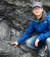 on Husson points to a fossilized tree stump at Joggins Fossil Cliffs, Nova Scotia - See more at: <a href=
