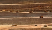 Trucks transporting soil in an open-pit coal mining site at Islamkot in the desert in the Tharparkar district of Pakistan.