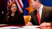 Arizona Gov. Doug Ducey speaks with New Mexico Gov. Susana Martinez prior to signing an agreement.