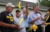 Rescued miner Thomas Foy throws up a piece of the ribbon he cut with fellow rescued miner John Unger (left).