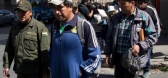 Police escort independent miners detained for questioning in the death of Bolivia's late Deputy Minister Of Internal Affairs.