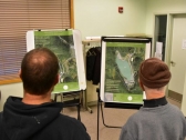 Members of the public examine maps of the proposed expansion to Coeur Alaska’s Kensington Mine.