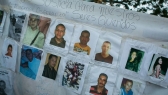 A banner with photos of several missing miners hangs on a tree near Tumeremo, Venezuela.